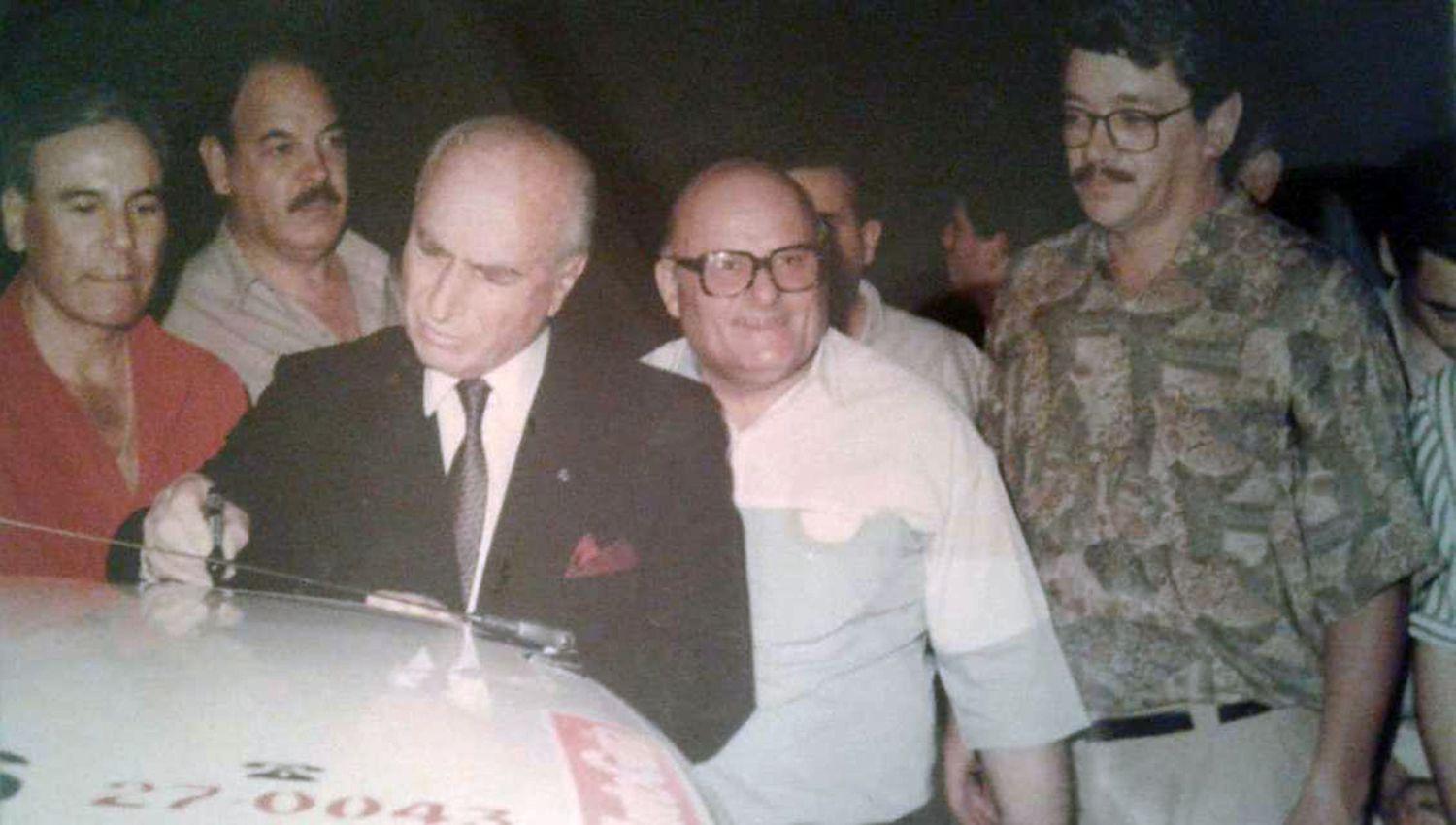 FIRMA Juan Fangio firmó varios autos con la compañia de Mil�n Janovich y Juan Carabajal (a la derECHA de Fangio)